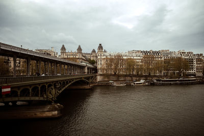 Bridge over river against cloudy sky