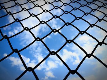 Full frame shot of chainlink fence against cloudy sky
