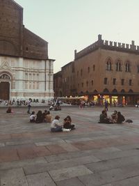 People at historic building in city against sky