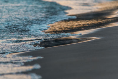 Full frame shot of wave in beach at sunset 