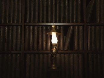 Close-up of illuminated light bulb hanging on ceiling