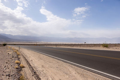Road by landscape against sky
