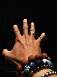 Close-up of hand gesturing against black background