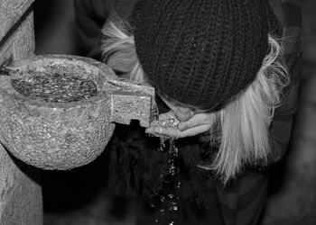 High angle view of woman drinking water from fountain