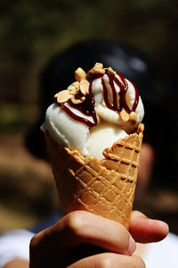 Close-up of hand holding ice cream cone