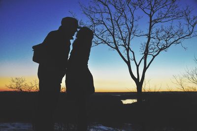 Silhouette of trees against sky at sunset