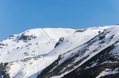 Scenic view of snowcapped mountains against clear blue sky