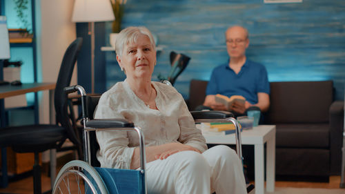 Portrait of senior woman sitting on wheelchair at home