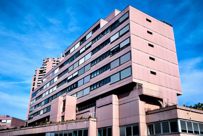 Low angle view of modern building against blue sky