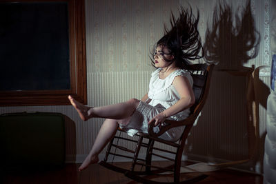 Woman sitting on chair at home