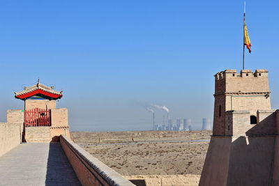 Lighthouse amidst buildings against sky