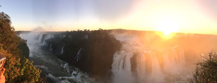 Panoramic view of waterfall against sky during sunset