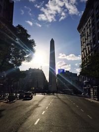 Sun shining through clouds over city