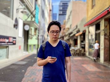 Portrait of young man standing in city