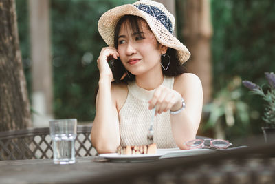 Young woman talking over mobile phone at outdoor cafe