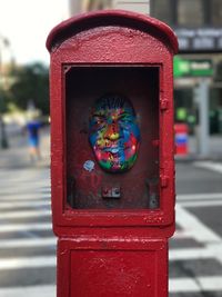 Close-up of red telephone in city