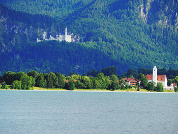 Scenic view of sea by buildings against mountain