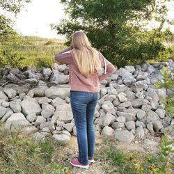 Rear view of woman standing on rock