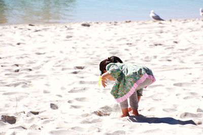 Full length of girl playing on sand at beach