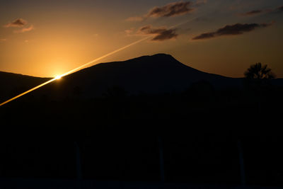 Scenic view of silhouette mountains against sky at sunset