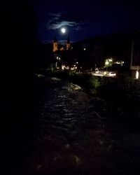 Illuminated road against sky at night