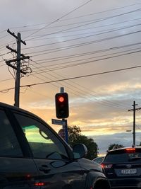 Telephone pole against sky during sunset