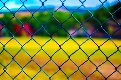 Full frame shot of soccer field seen through chainlink fence