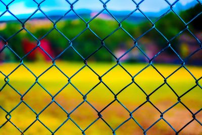 Full frame shot of soccer field seen through chainlink fence