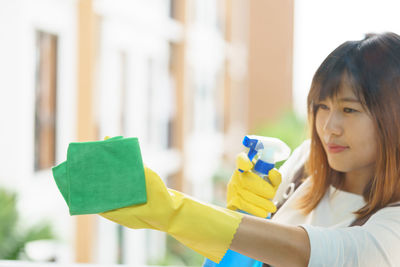 Portrait of smiling woman holding yellow indoors