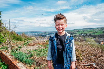 Portrait of smiling man standing on land against sky