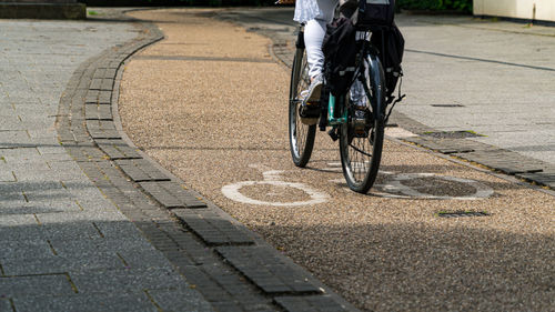 Low section of person riding bicycle on road