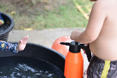 Midsection of people holding hands in water