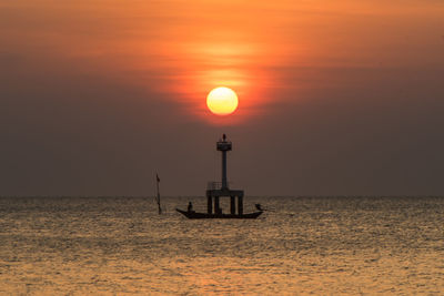 Silhouette sailboat in sea against sky during sunset