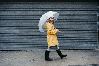 Full length of man standing against yellow wall