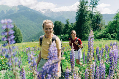 Two women hikers with backpacks walk along a mountain path.