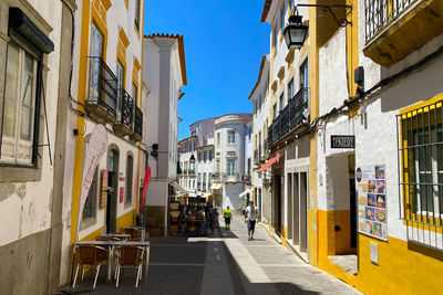 People walking on street amidst buildings in city