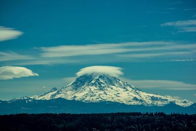 Scenic view of snowcapped mountains against blue sky