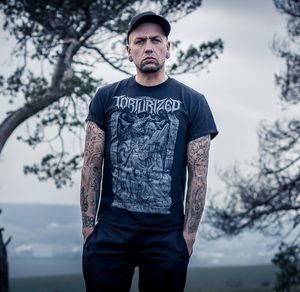 Young man standing against trees