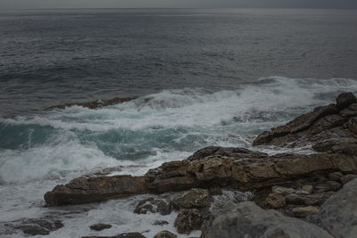 Scenic view of rocks on sea shore