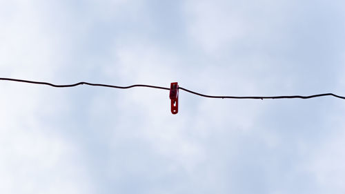 Red clothespin on the wire and the sky is clearred