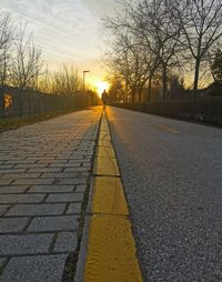 Surface level of road against sky during sunset