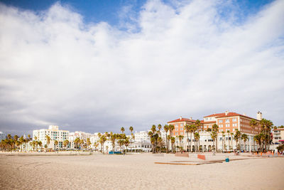 Buildings in town against cloudy sky