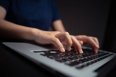 Close-up of man using smart phone on table