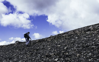 Low angle view of man on rock against sky