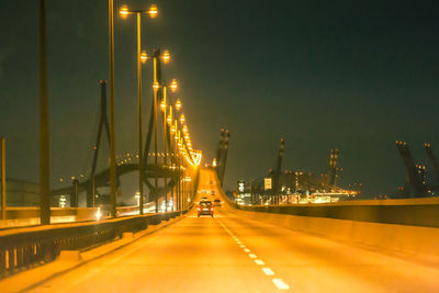 Illuminated bridge against sky at night