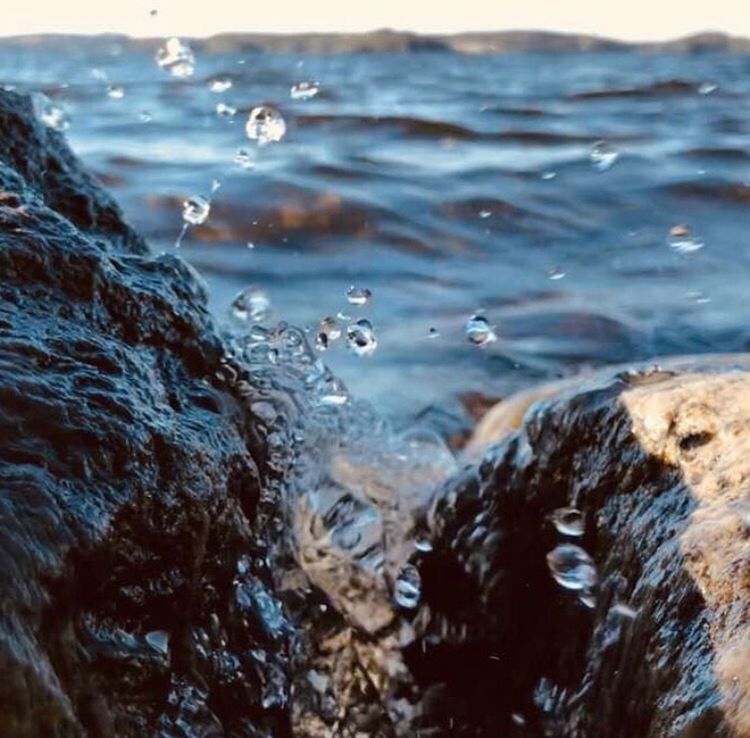 CLOSE-UP OF WATER SURFACE LEVEL OF ROCKS