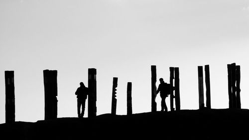 Silhouette people standing against clear sky