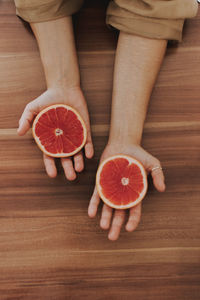 Midsection of woman with fruits on table