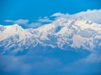 Scenic view of snowcapped mountains against blue sky