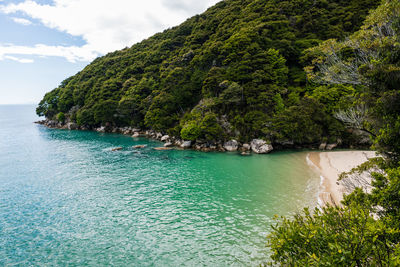 Scenic view of tropical bay with sandy beach against sky